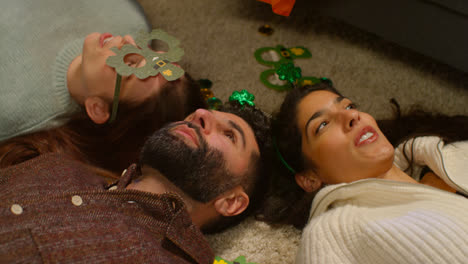 Group-Of-Friends-Lying-On-Floor-Dressing-Up-With-Irish-Novelties-And-Props-At-Home-For-St-Patrick's-Day-Party